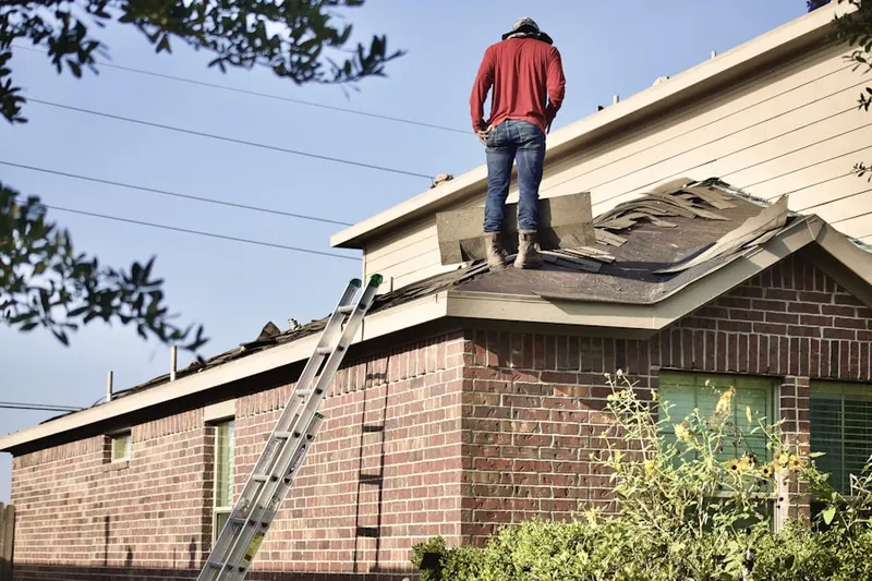 Professional roofer working on a residential roof in Weinland Park